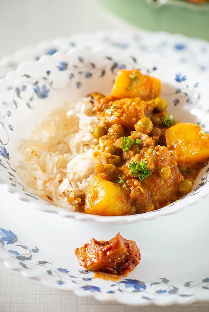 Potatoes and peas curry served with steamed rice